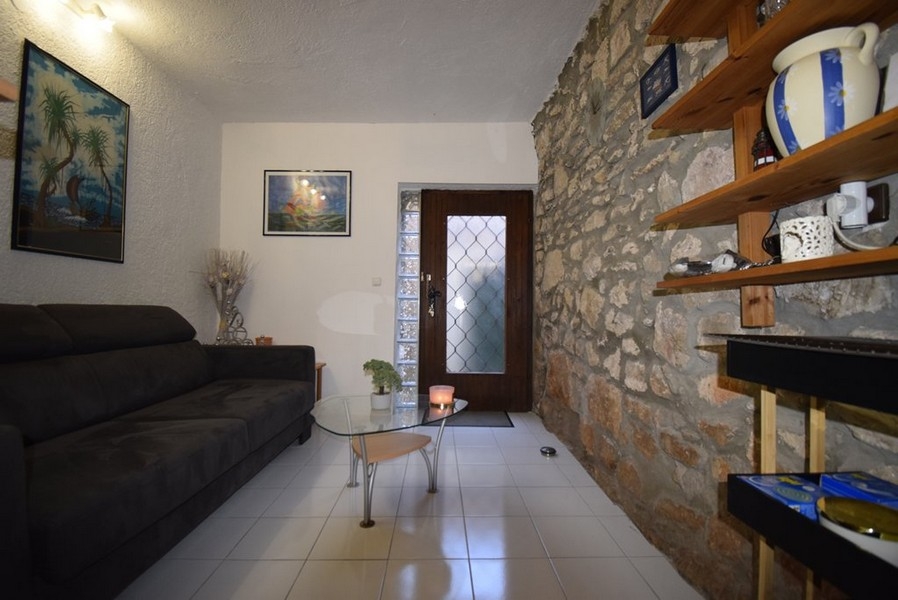 Séjour avec mur en pierre et canapé
