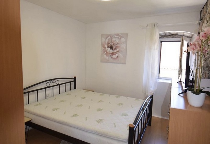 Chambre avec lit double et mur en pierre