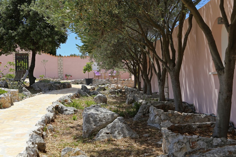 Allée de jardin avec arbres et pierres naturelles à côté de la maison