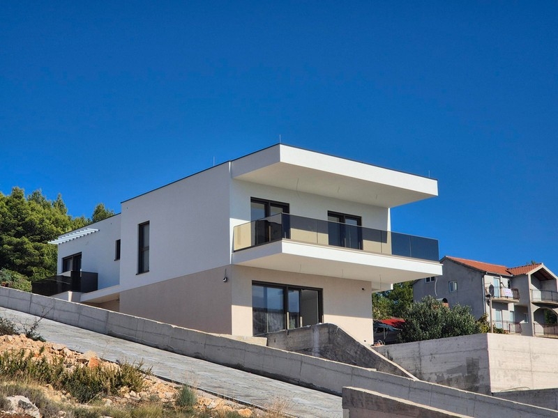 Construction neuve blanche avec balcon au-dessus du mur de soutènement en béton
