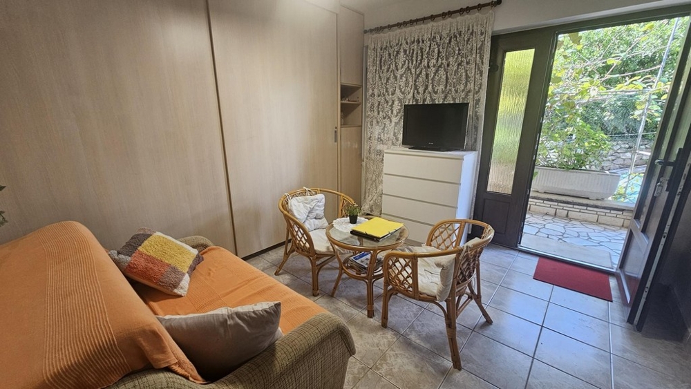 Séjour au rez-de-chaussée avec canapé et meubles en rotin