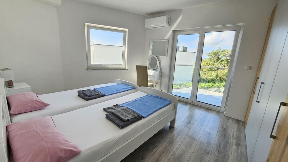Chambre avec deux lits et accès au balcon