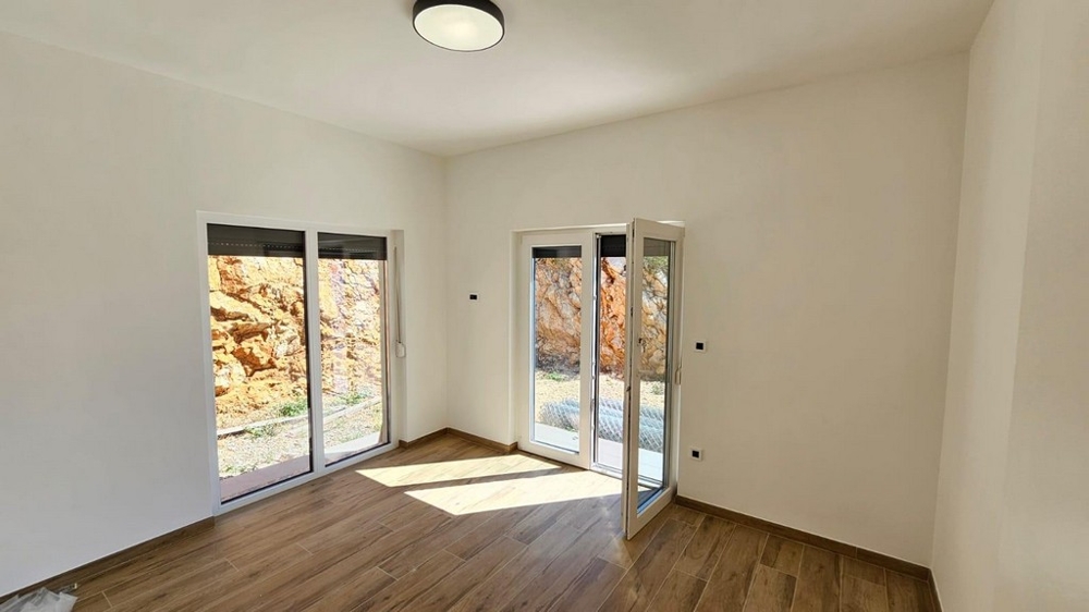 Chambre avec baies vitrées du sol au plafond et vue sur les rochers