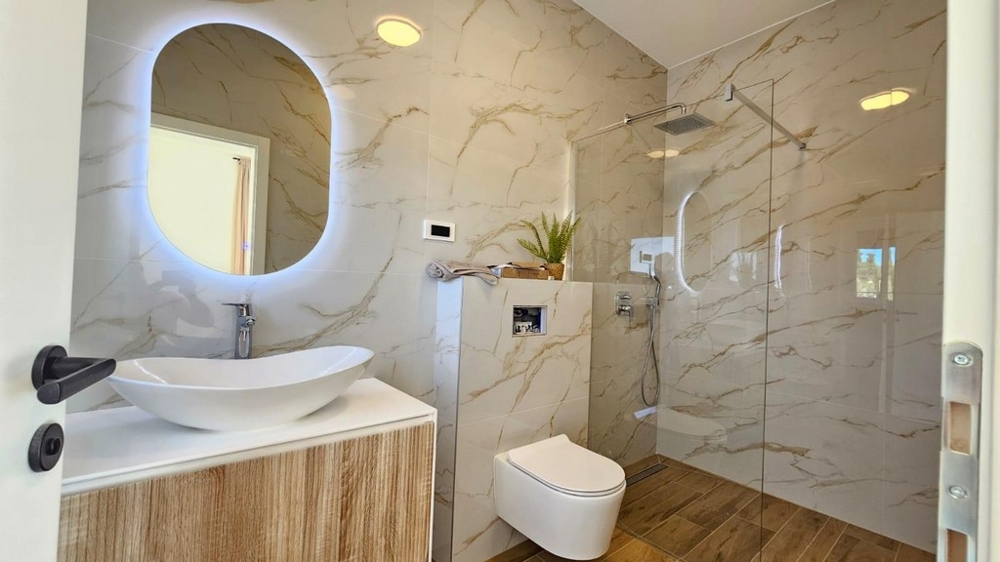 Salle de bains moderne avec douche, meuble-lavabo et WC