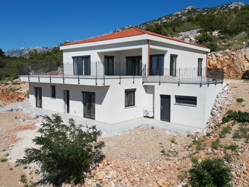 Maison blanche avec balcon sur tout le tour devant la paroi rocheuse