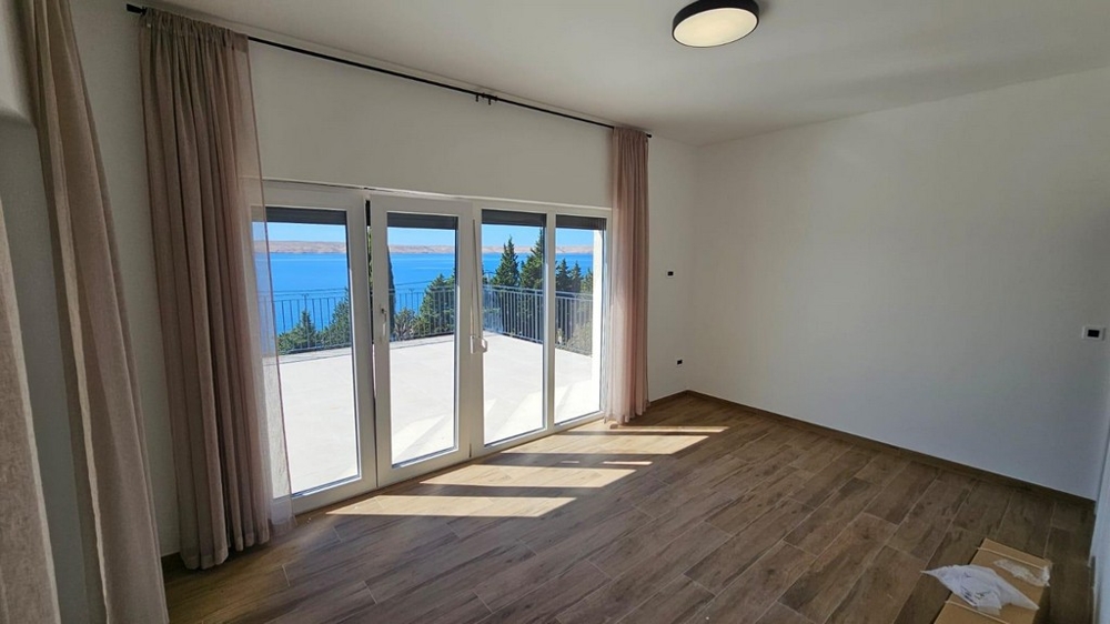 Pièce avec grandes baies vitrées et vue mer