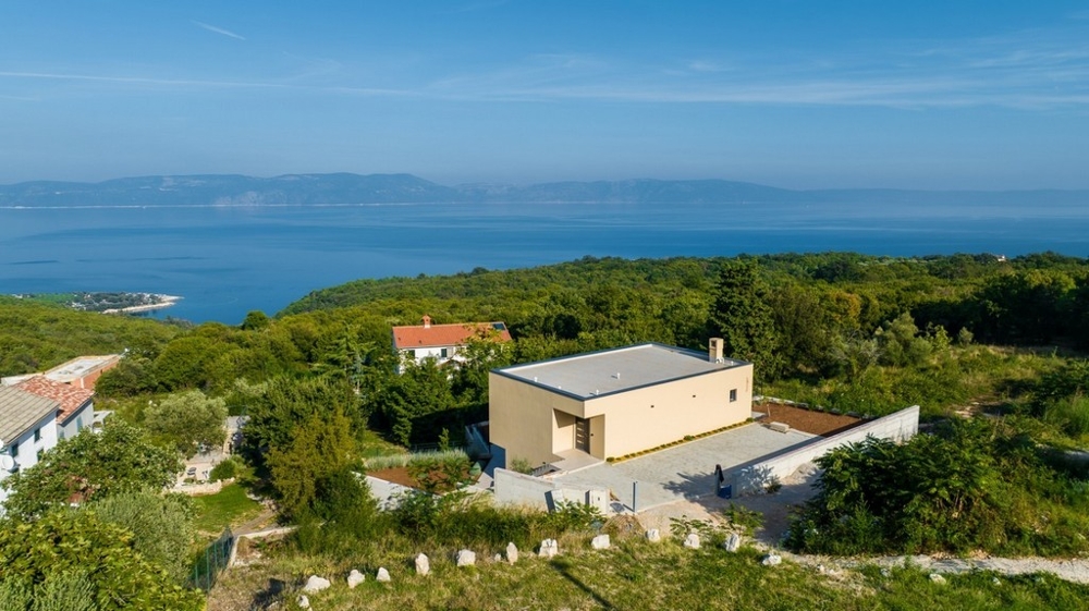 Vue aérienne de la maison avec vue par-dessus la forêt jusqu'à la mer