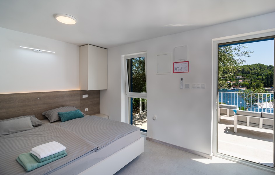 Chambre avec lit double et accès au balcon avec vue mer