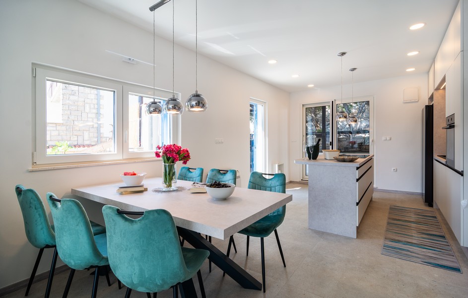 Coin repas avec grande table et cuisine moderne
