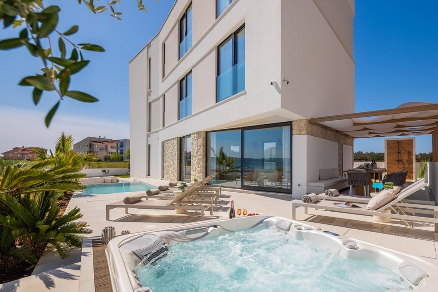 Jacuzzi sur la terrasse avec piscine et pergola derrière