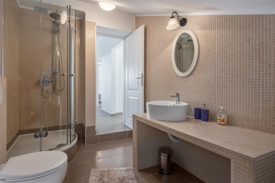 Salle de bains avec douche ronde et coin lavabo