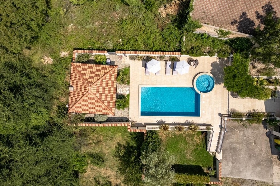 Vue aérienne du toit de tuiles et de la piscine avec parasols