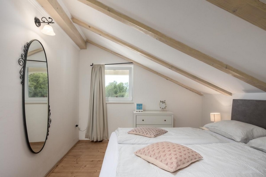 Chambre confortable sous les combles avec poutres en bois