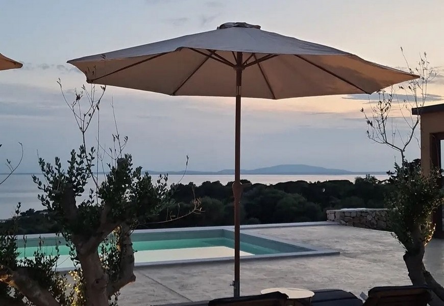 Parasol au bord de la piscine avec vue sur la mer jusqu'à l'île