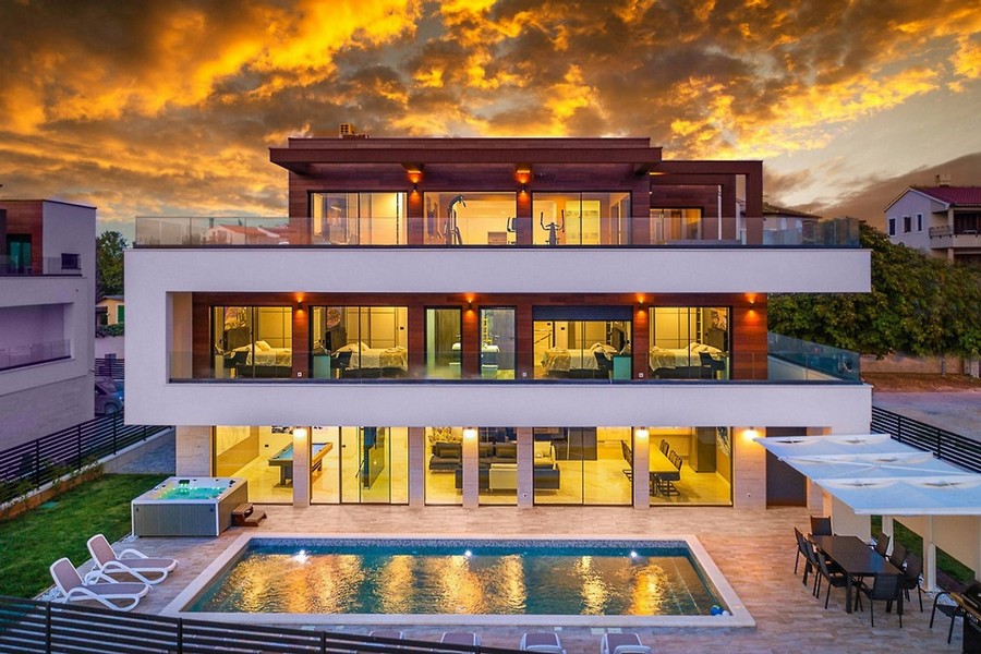 Villa éclairée avec piscine et jacuzzi au soleil couchant