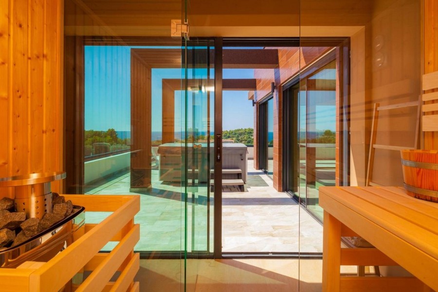 Sauna avec façade vitrée et accès à la terrasse avec vue mer
