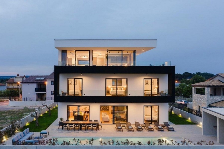 Villa éclairée sur trois niveaux avec piscine au crépuscule
