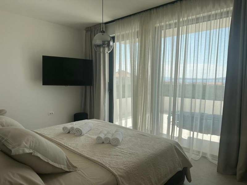 Chambre avec balcon et vue mer à travers la grande baie vitrée