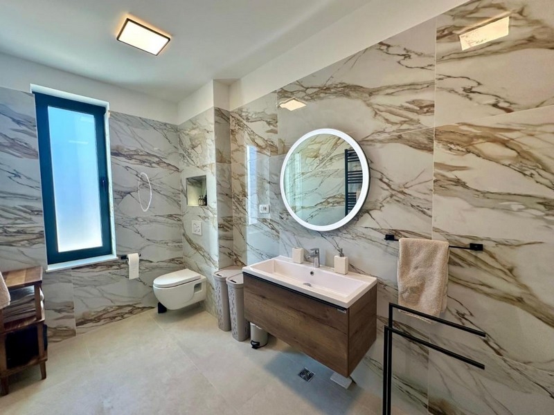 Salle de bains moderne avec double vasque et murs en marbre
