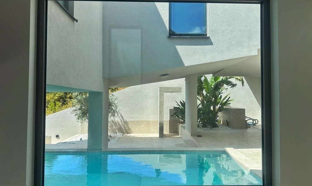 Vue de l'intérieur sur la piscine et le patio