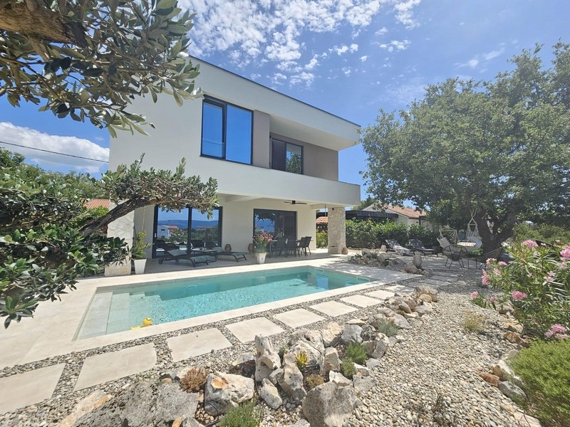 Maison blanche avec piscine entre un olivier et un massif de gravier