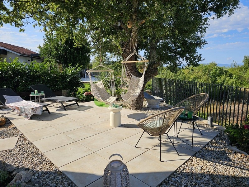 Solarium avec fauteuils suspendus et vue sur le jardin