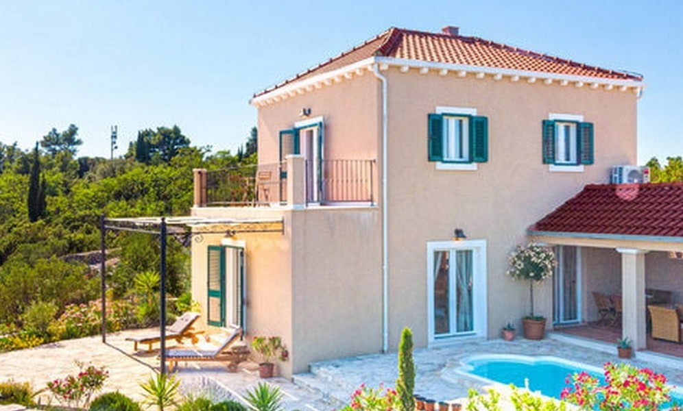 Maison beige avec pergola et piscine dans le jardin