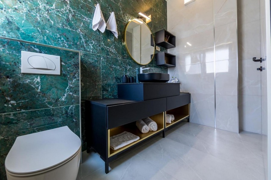 Salle de bains avec mur en marbre vert et meuble-lavabo moderne