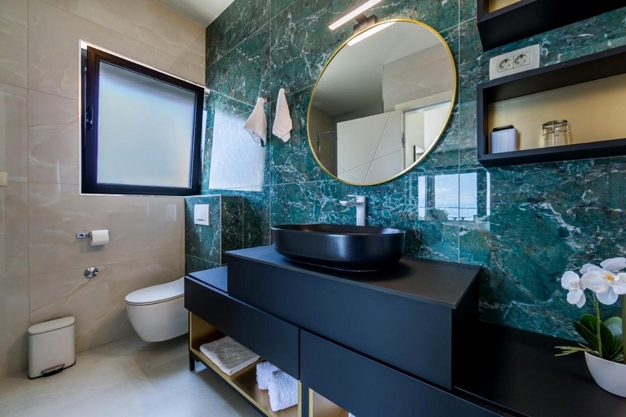 Salle de bains avec meuble-lavabo noir et équipement élégant
