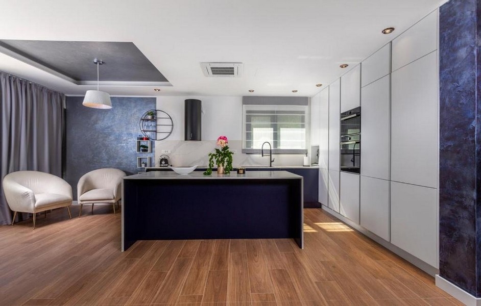 Cuisine équipée moderne avec îlot de cuisson et coin salon