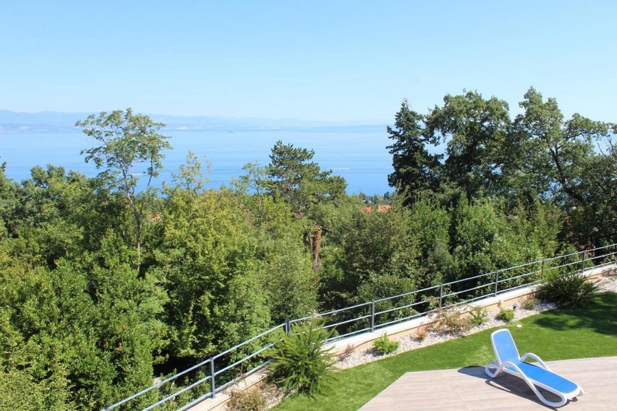 Transat sur la pelouse avec vue par-dessus la cime des arbres jusqu'à la mer