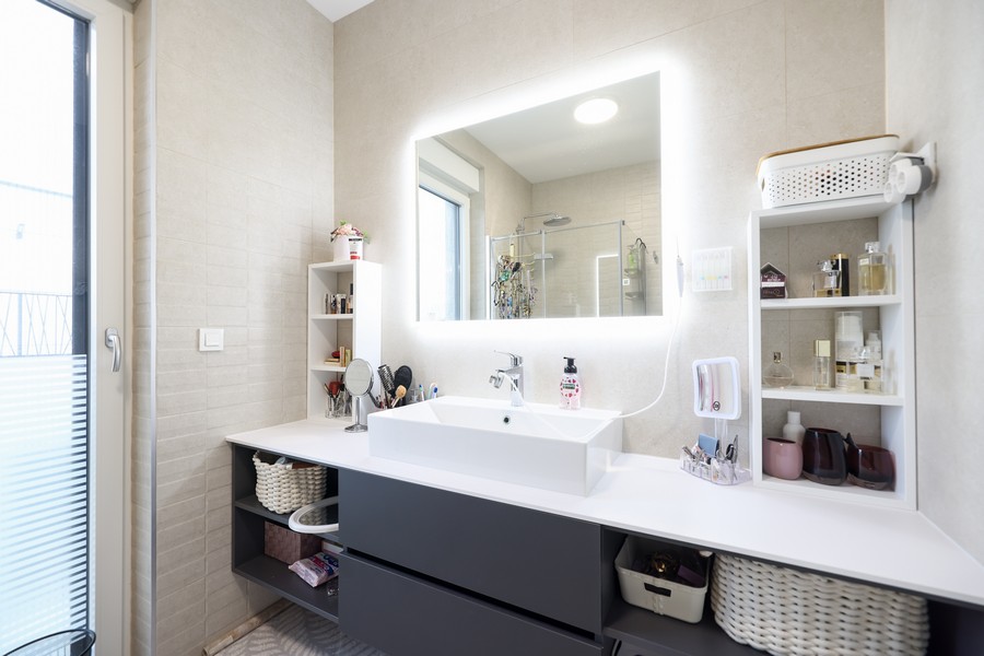 Salle de bains avec meuble-lavabo et miroir éclairé