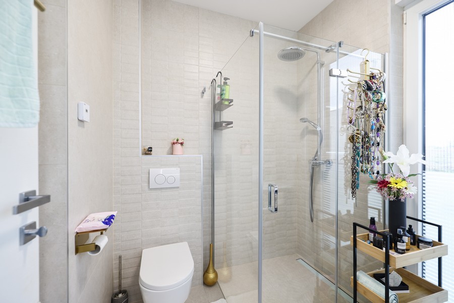 Espace douche avec paroi en verre et WC suspendu