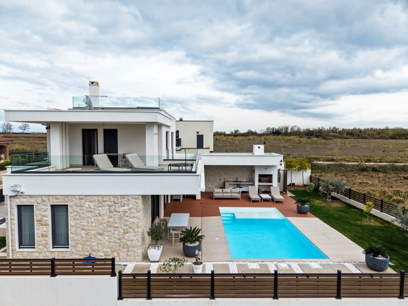 Vue latérale de la villa avec grande terrasse et piscine