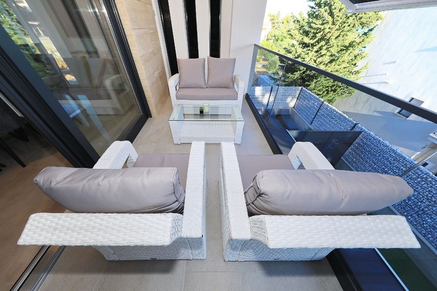 Coin salon sur balcon avec garde-corps en verre