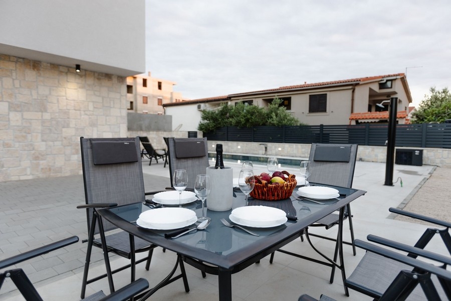 Coin repas sur la terrasse avec vue sur la piscine