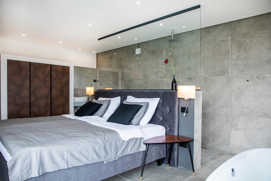 Chambre grise avec paroi vitrée.