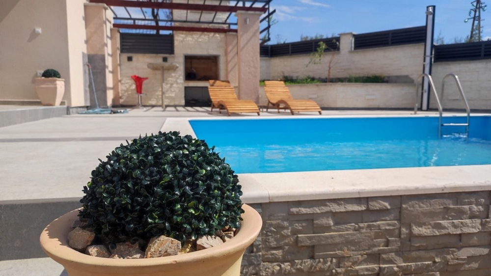 Espace piscine et cuisine d'été.
