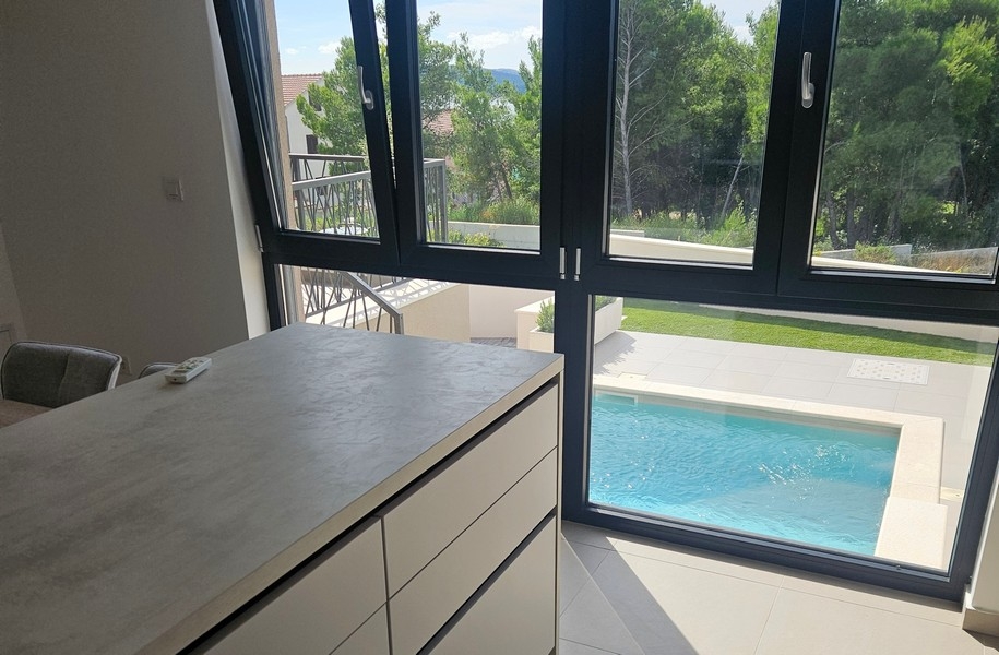 Cuisine avec vue sur la piscine et le jardin