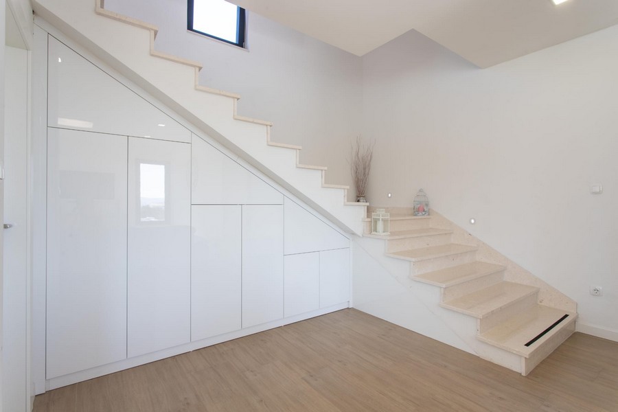 Escalier avec placard encastré blanc dessous dans le couloir
