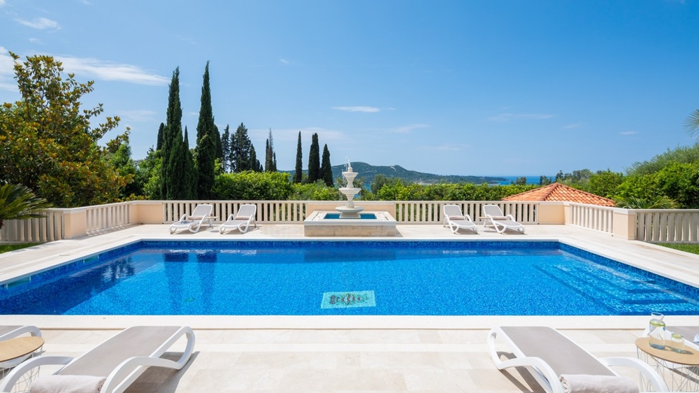 Terrasse de la piscine avec transats et vue sur la mer