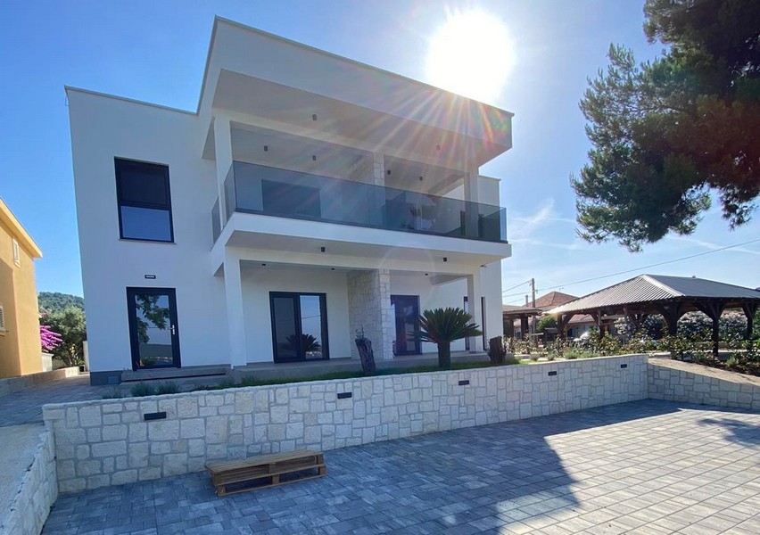 Villa blanche avec garde-corps en verre à contre-jour