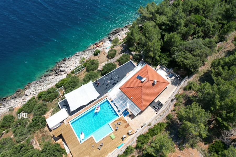 Vue aérienne de la villa en première ligne sur la mer avec piscine et solarium