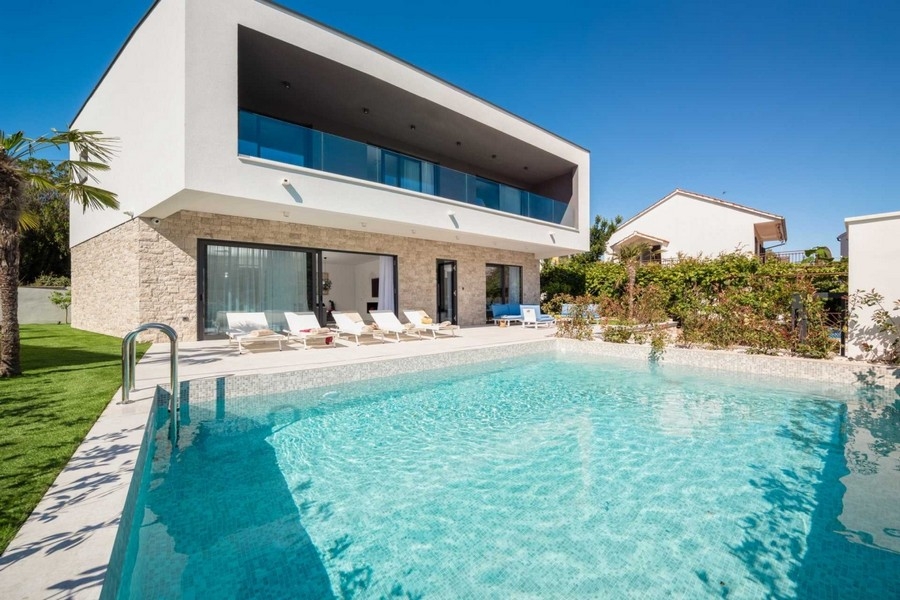 Villa claire à soubassement en pierre avec longue piscine devant