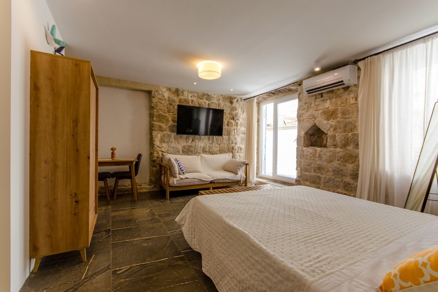 Chambre avec mur en pierre naturelle et climatisation
