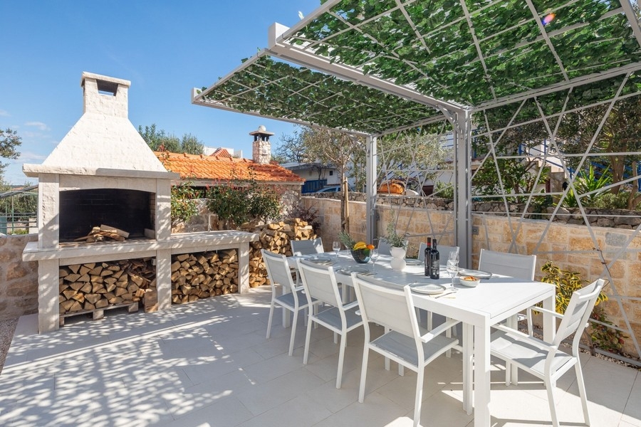 Cuisine extérieure avec cheminée-barbecue et coin salon couvert