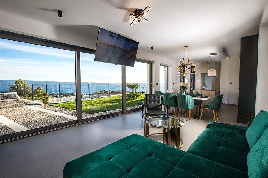 Séjour moderne avec grandes façades vitrées et vue mer