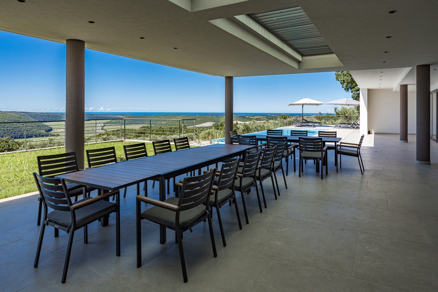 Terrasse couverte avec grande table à manger et vue lointaine