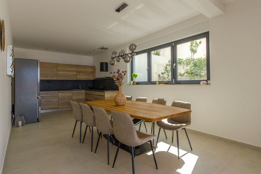 Coin repas avec grande table en bois et éclairage moderne