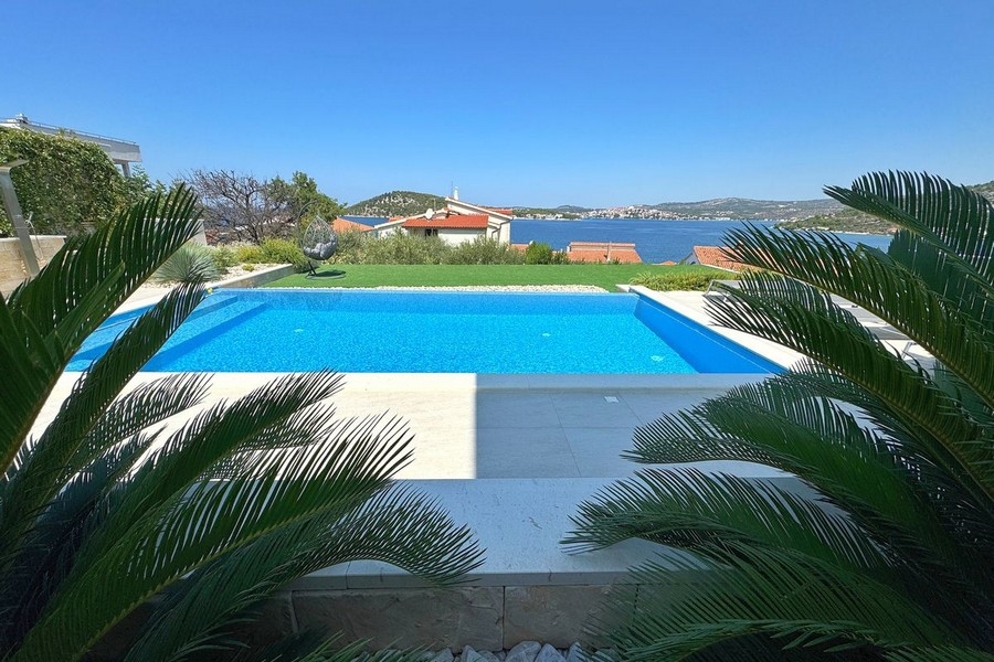Piscine avec solarium et vue sur la baie